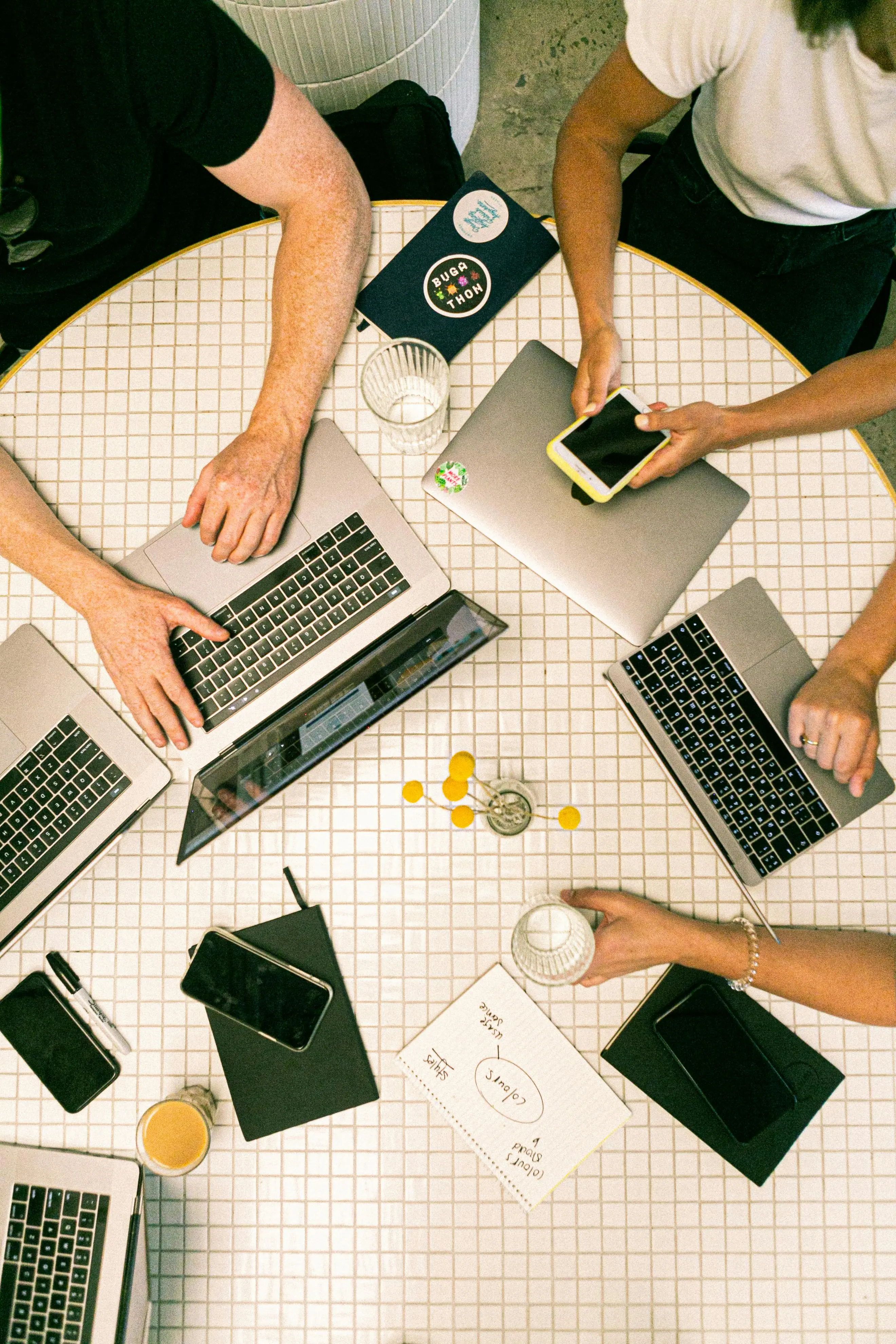 Man smiling at a computer holding a cup of coffee